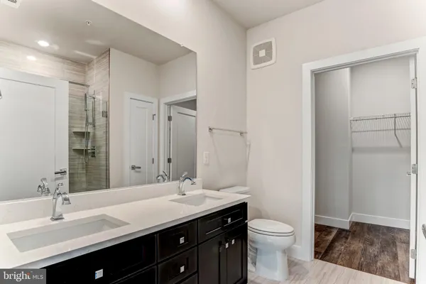 a bathroom with a double vanity sink toilet and a mirror