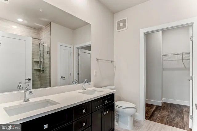 a bathroom with a double vanity sink toilet and a mirror
