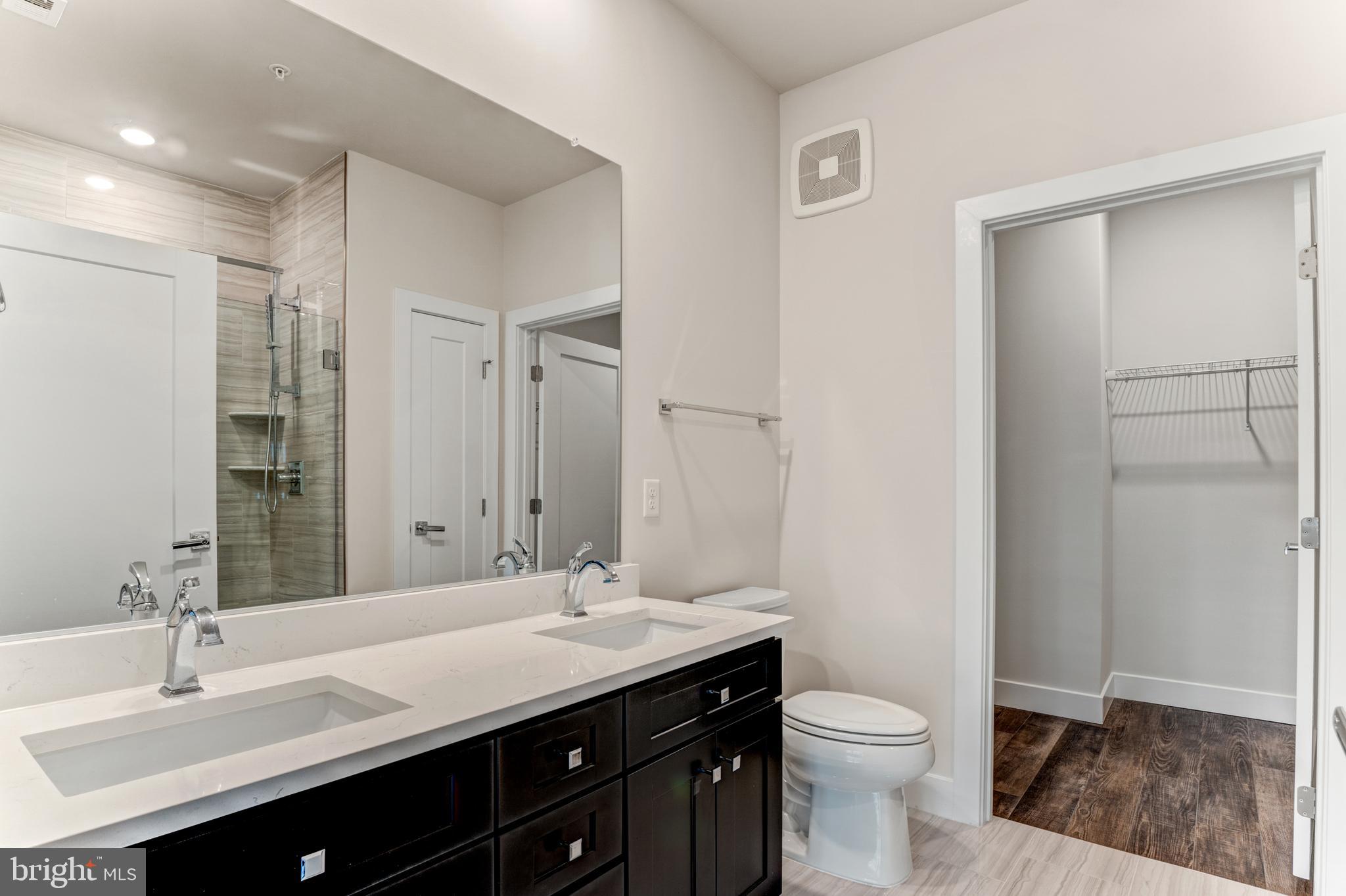 1761 Old Meadow Road, Unit 209 McLean, VA 22102 - Photo 11 of 58 a bathroom with a double vanity sink toilet and a mirror