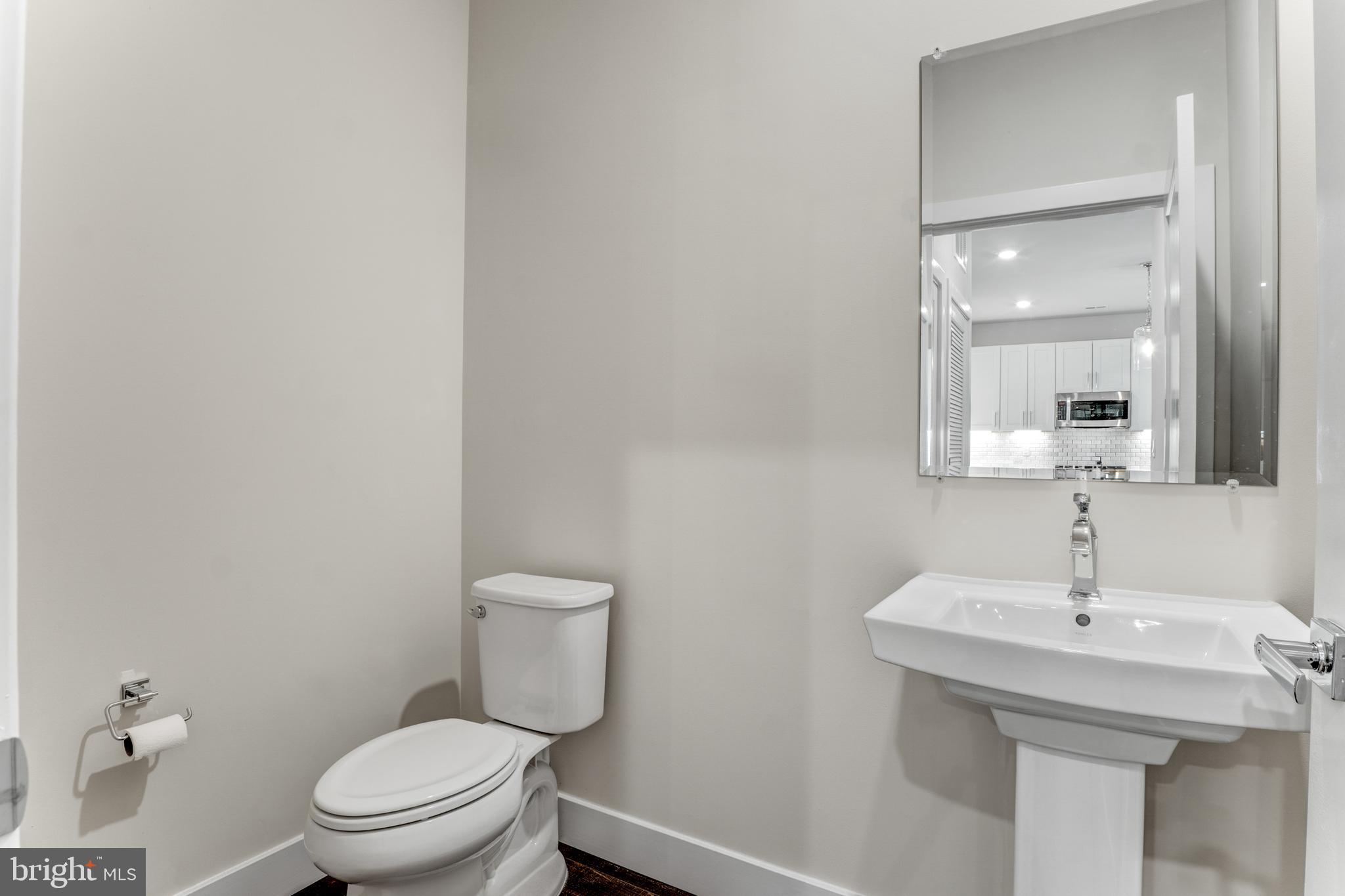 1761 Old Meadow Road, Unit 209 McLean, VA 22102 - Photo 20 of 58 a bathroom with a toilet a sink and mirror