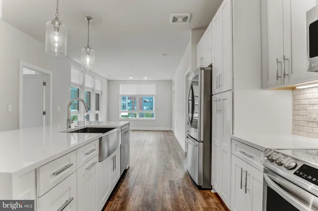a kitchen with granite countertop a refrigerator stove and sink