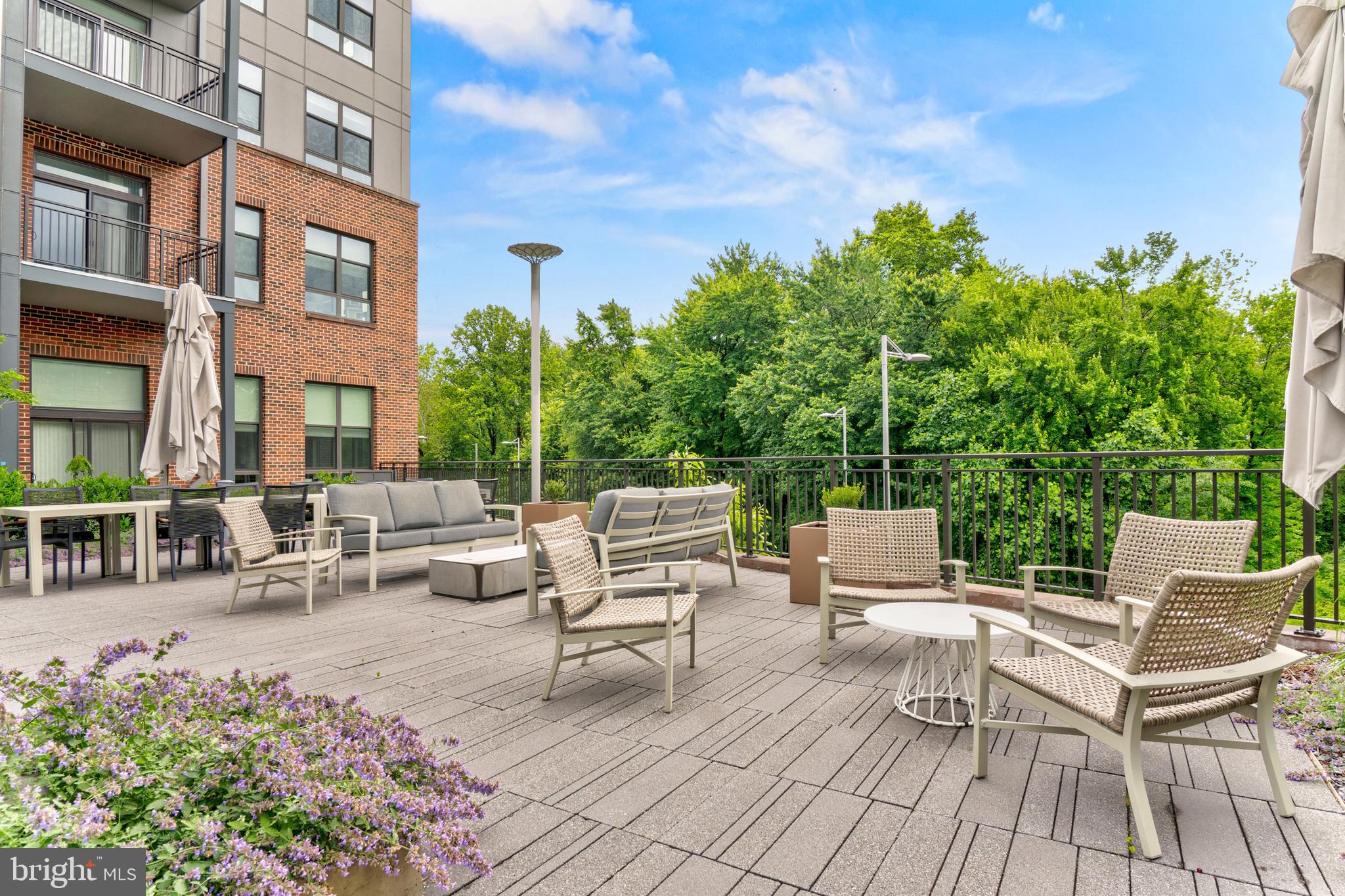 1761 Old Meadow Road, Unit 209 McLean, VA 22102 - Photo 37 of 58 a view of a patio with couches and table and chairs with wooden fence and plants