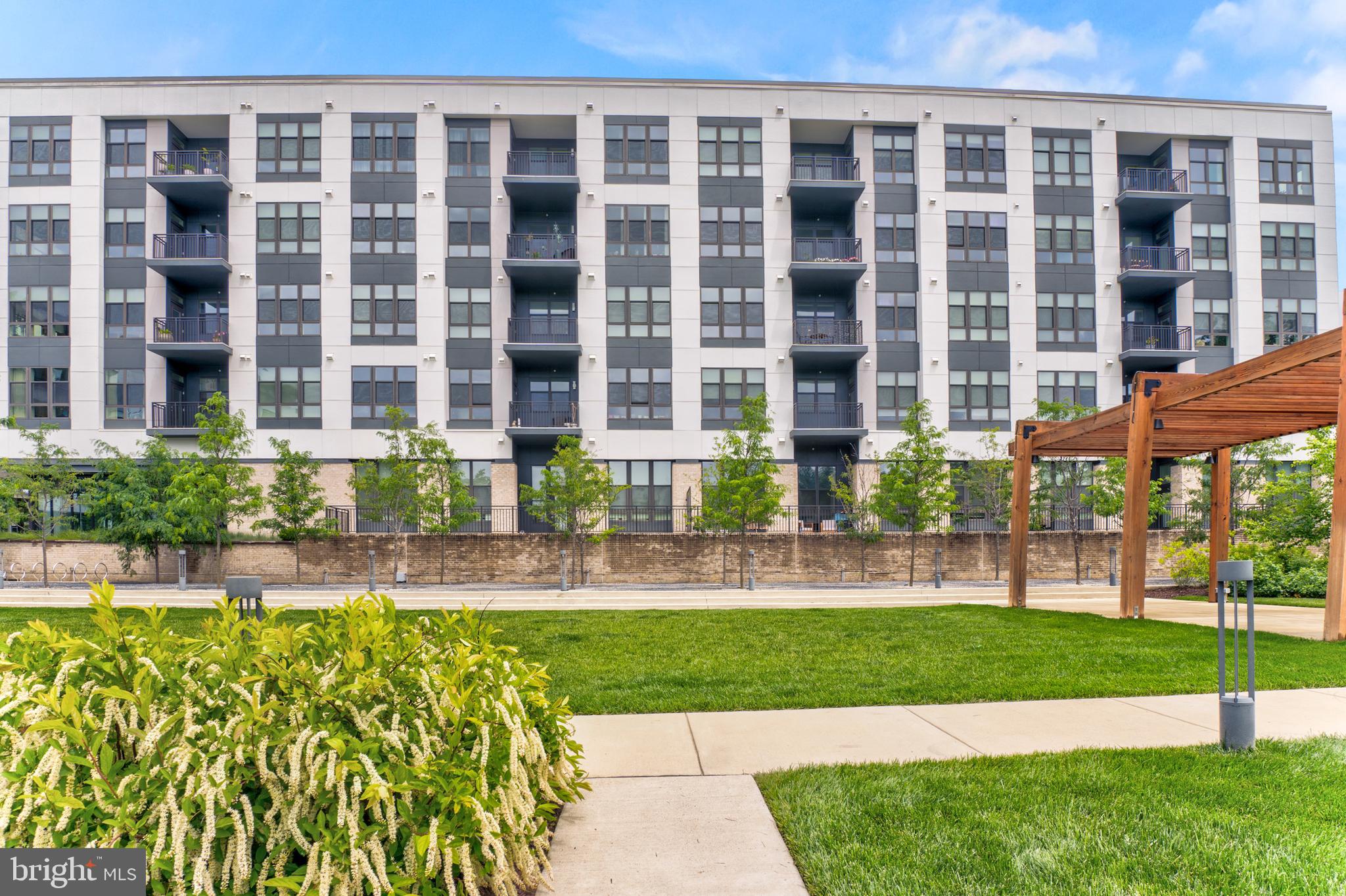 1761 Old Meadow Road, Unit 209 McLean, VA 22102 - Photo 48 of 58 a front view of a building with a garden and pathway
