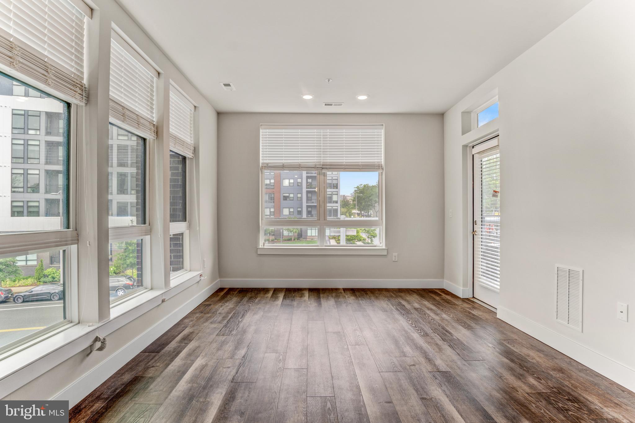 1761 Old Meadow Road, Unit 209 McLean, VA 22102 - Photo 5 of 58 a view of an empty room with wooden floor and a window