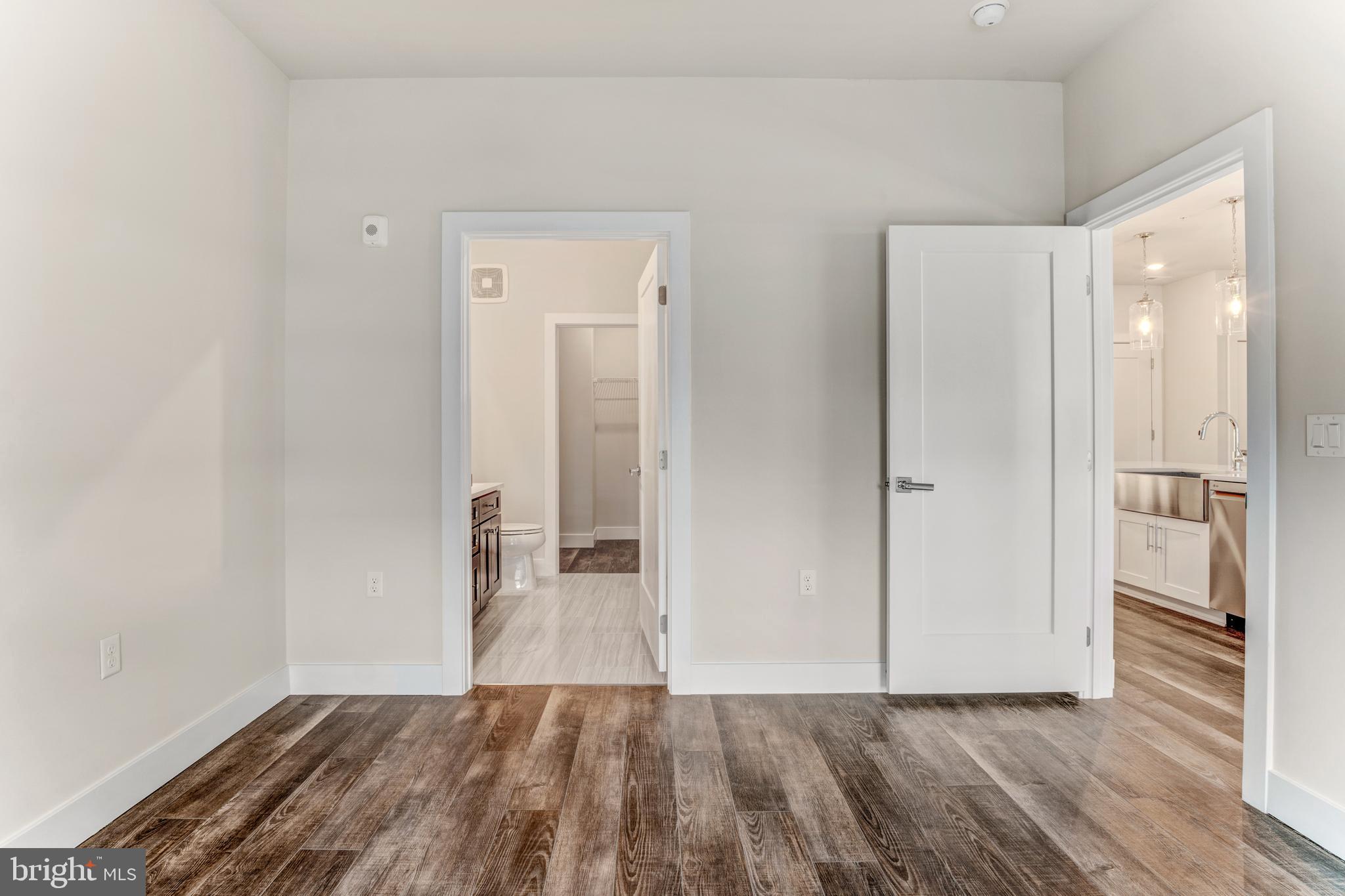 1761 Old Meadow Road, Unit 209 McLean, VA 22102 - Photo 9 of 58 a view of a hallway with wooden floor and a bathroom
