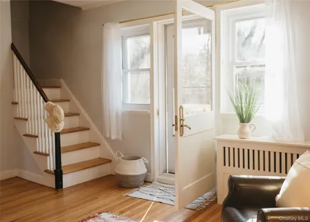 a view of a hallway with wooden floor and windows