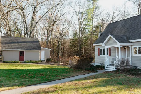 a view of a house with a big yard plants and large trees