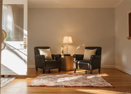 a view of a livingroom with chairs and wooden floor