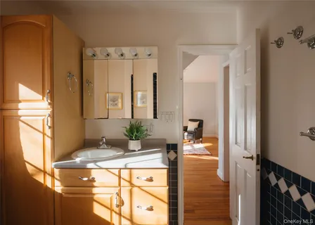 a en suite bathroom with a granite countertop sink and a large mirror