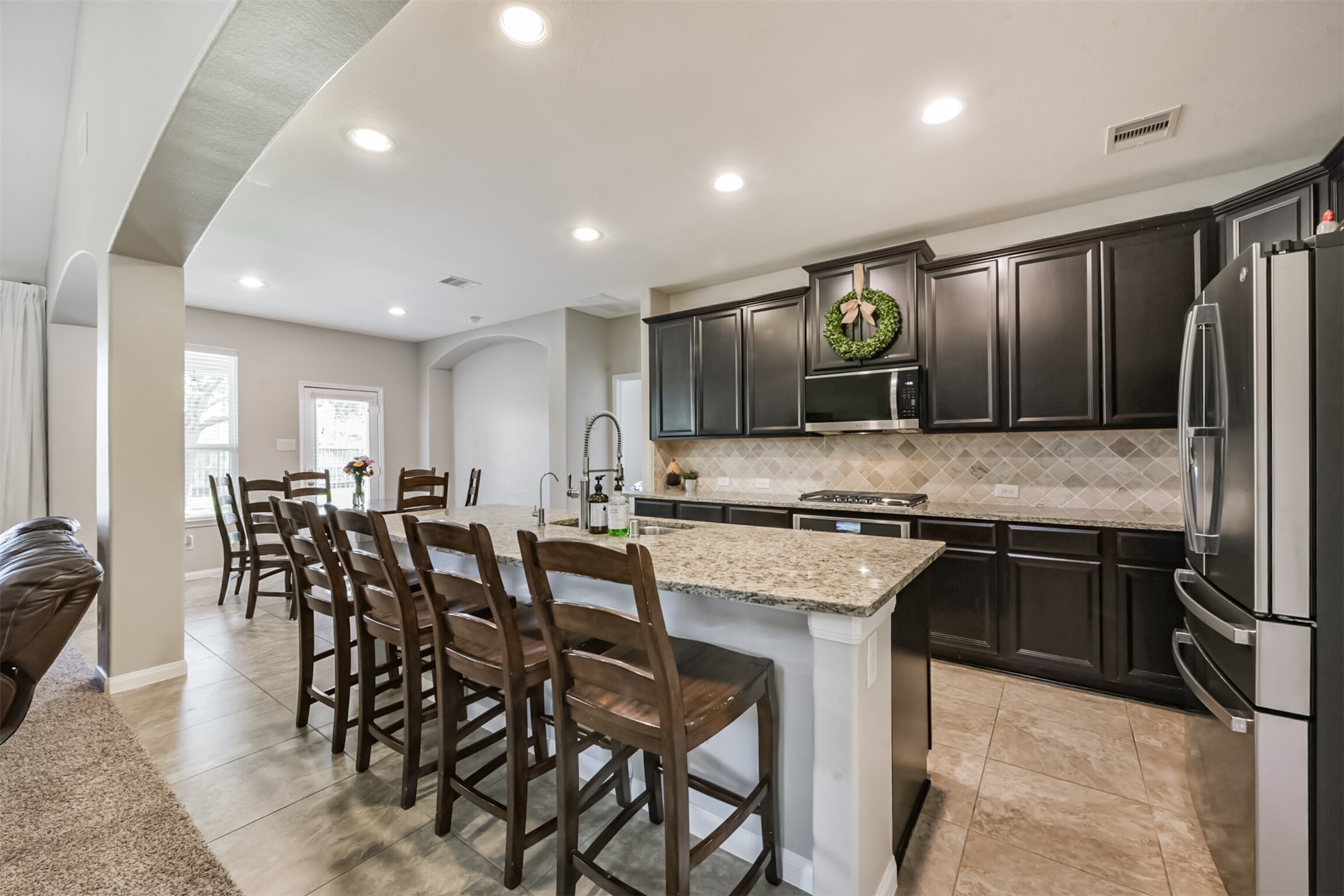 17120 Edge Branch Lane Houston, TX 77044 - Photo 11 of 50 a kitchen with stainless steel appliances granite countertop table chairs stove refrigerator and cabinets