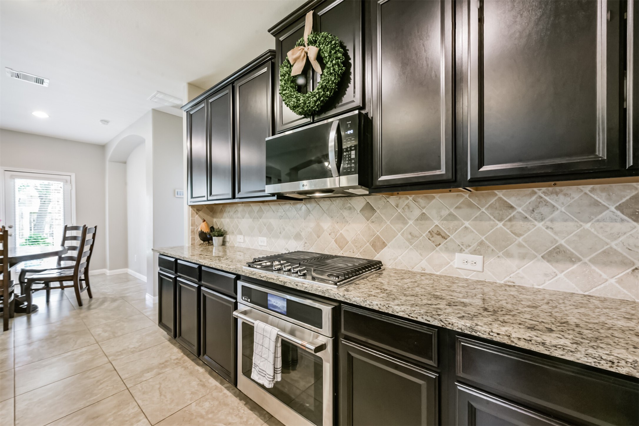 17120 Edge Branch Lane Houston, TX 77044 - Photo 16 of 50 a kitchen with granite countertop a stove top oven and cabinets