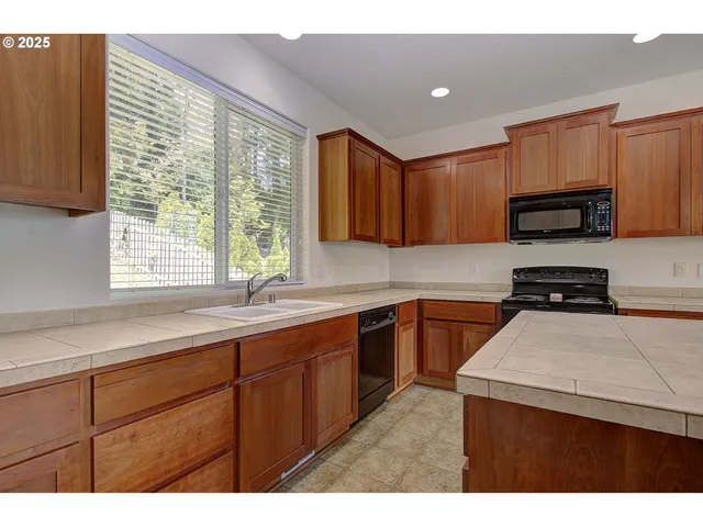 a kitchen with a sink a window and appliances