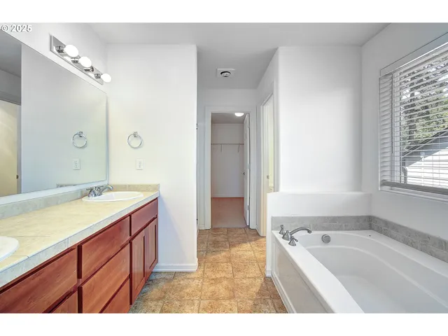 a bathroom with a tub sink and mirror