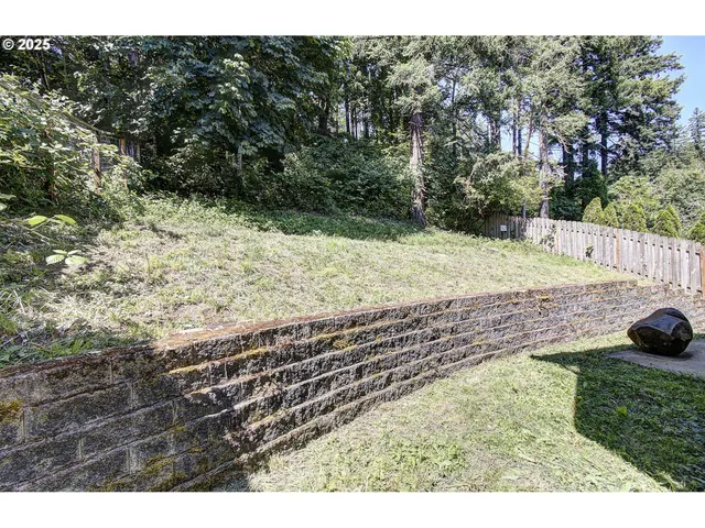 a view of a yard with wooden fence