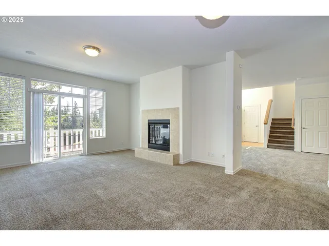 a view of an empty room with a fireplace and a window