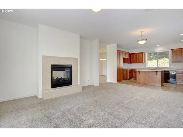 a view of a big room with kitchen fireplace and a window