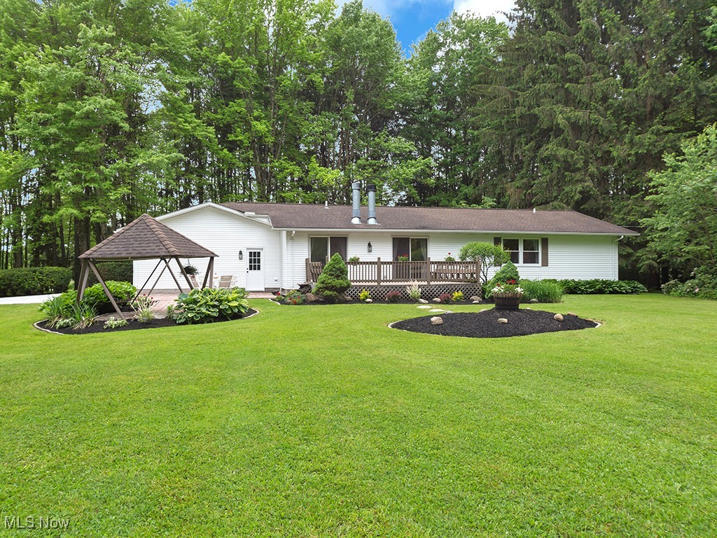 11050 Bell Road Newbury, OH 44065 - Photo 24 of 38 View of the back of the home and showing the gazebo, Deck, back yard, and wooded area.
