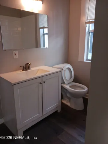 a utility room with a sink a toilet and a window