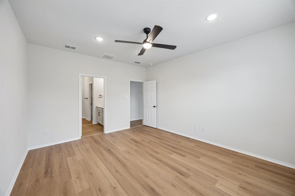 1006 Voca Dr. Forney, TX 75126 - Photo 13 of 26 a view of an empty room with wooden floor and a ceiling fan