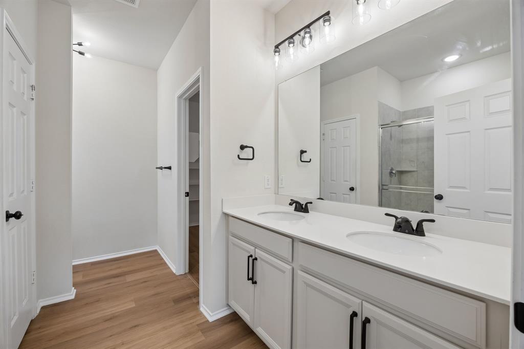 1006 Voca Dr. Forney, TX 75126 - Photo 16 of 26 a en suite bathroom with a granite countertop sink and a mirror