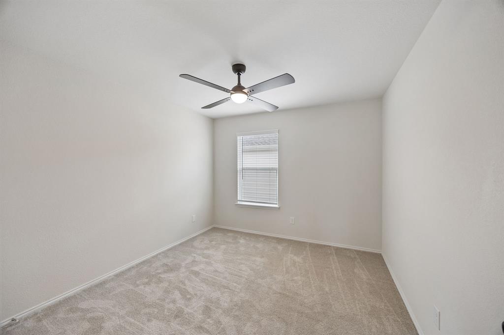 1006 Voca Dr. Forney, TX 75126 - Photo 24 of 26 an empty room with a chandelier fan and windows