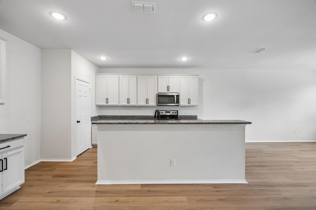 1006 Voca Dr. Forney, TX 75126 - Photo 6 of 26 a kitchen with stainless steel appliances granite countertop a stove a sink and a refrigerator
