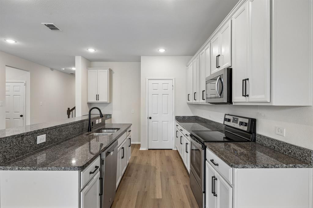1006 Voca Dr. Forney, TX 75126 - Photo 7 of 26 a kitchen with stainless steel appliances granite countertop a sink stove and cabinets
