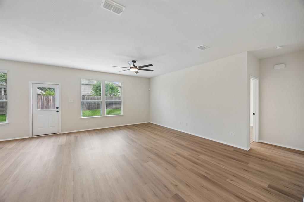 1006 Voca Dr. Forney, TX 75126 - Photo 9 of 26 an empty room with wooden floor chandelier and windows