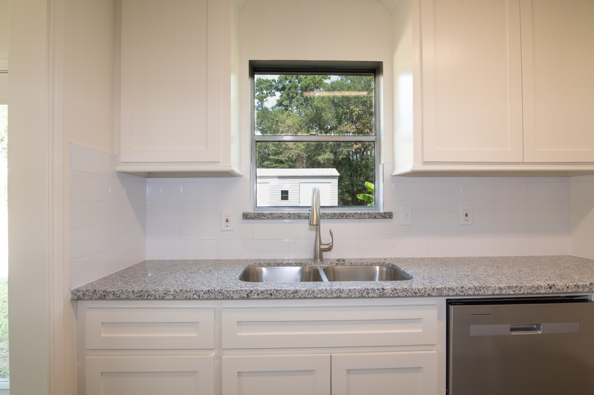 13087 Crystal Trail Conroe, TX 77306 - Photo 20 of 47 a kitchen with granite countertop a sink and a window