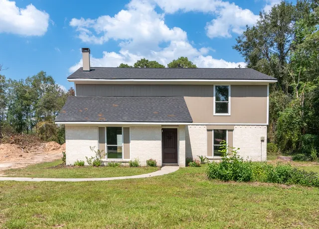 a front view of a house with a garden and yard