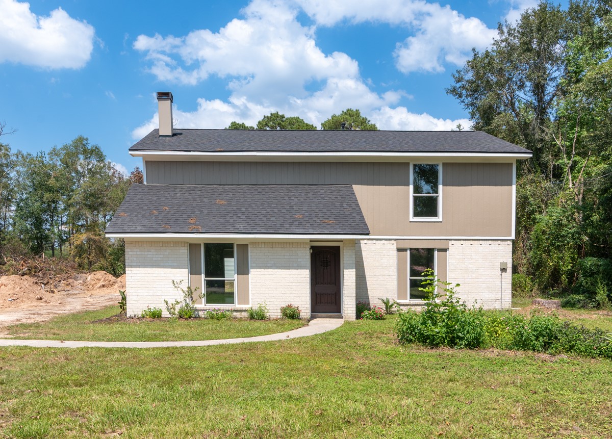 13087 Crystal Trail Conroe, TX 77306 - Photo 2 of 47 a front view of a house with a garden and yard