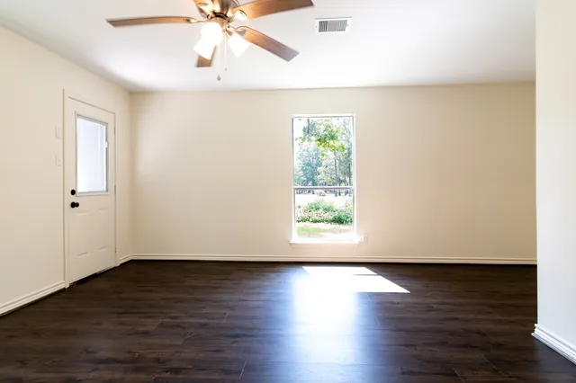 a view of a room with wooden floor and white walls