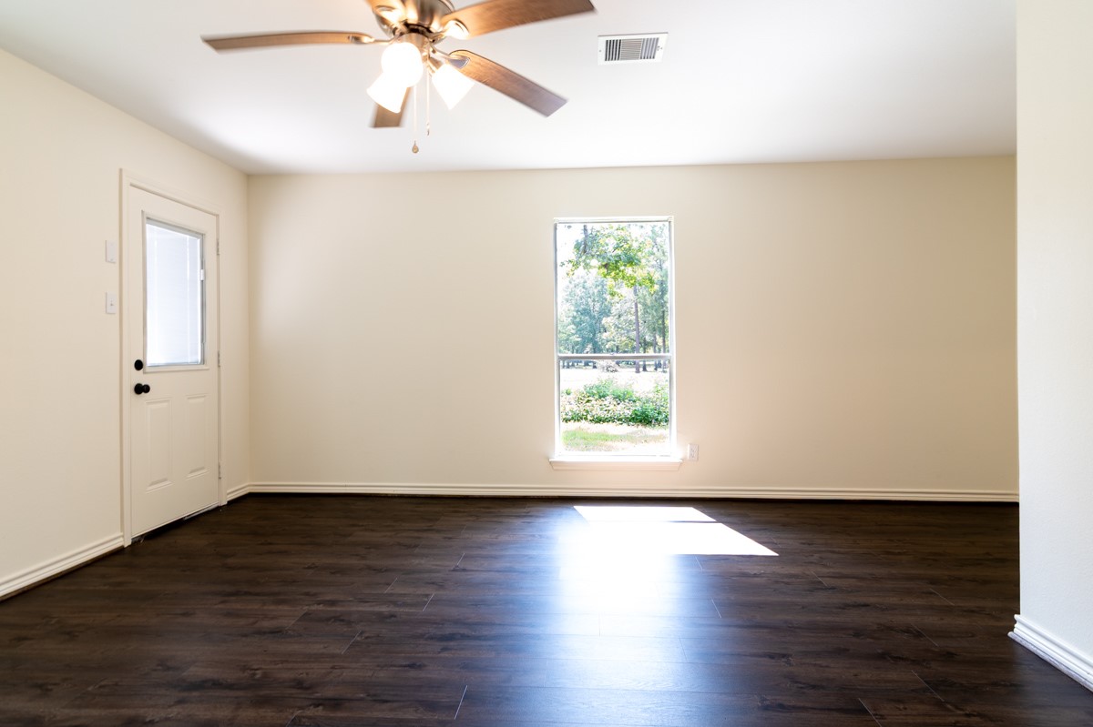 13087 Crystal Trail Conroe, TX 77306 - Photo 26 of 47 an empty room with wooden floor and windows