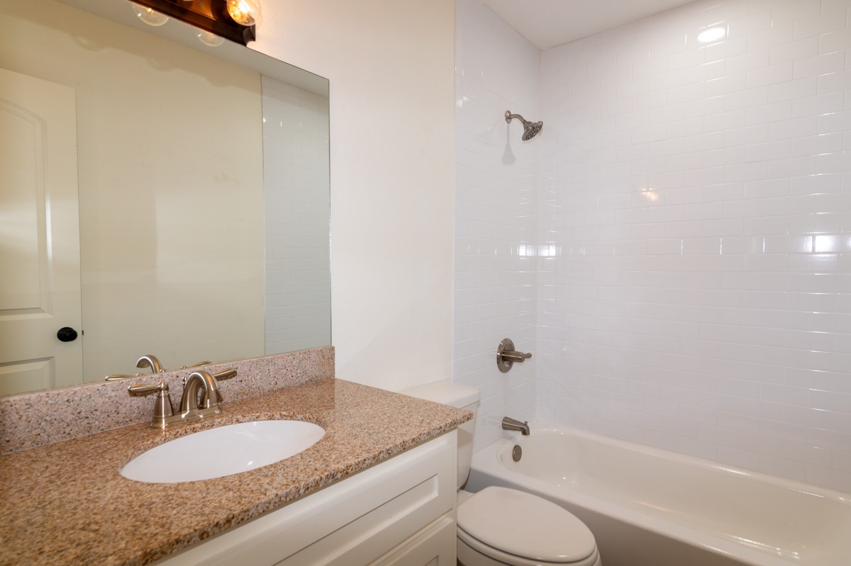 13087 Crystal Trail Conroe, TX 77306 - Photo 34 of 47 a bathroom with a granite countertop sink toilet and shower