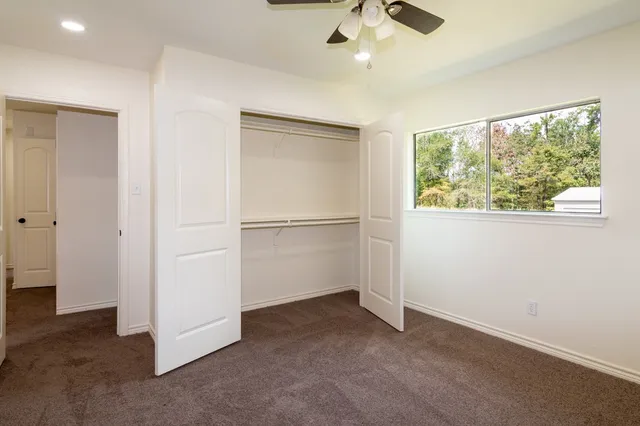 an empty room with a window and a fan