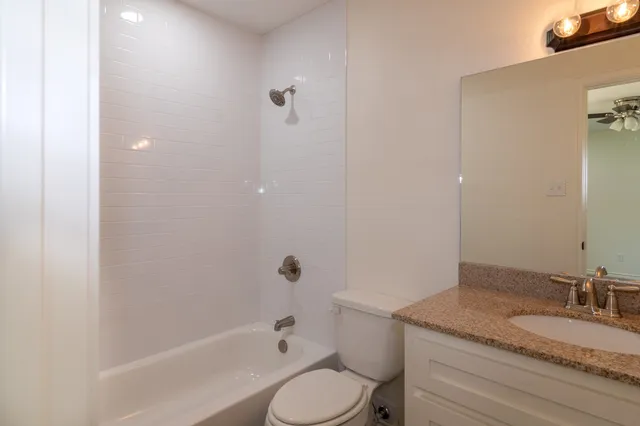 an empty room with closet and a ceiling fan