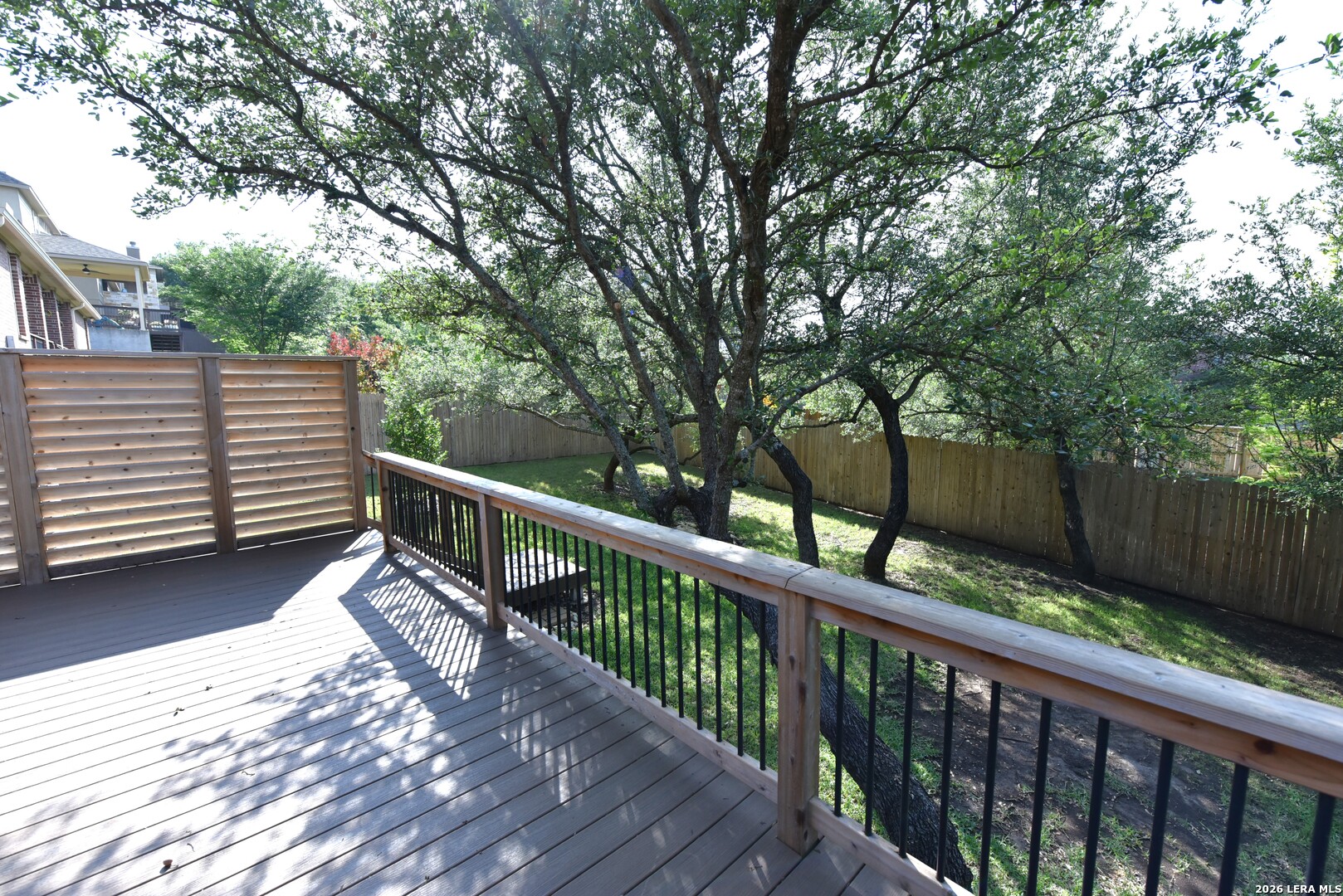 8907 Irving Hill Fair Oaks Ranch, TX 78015 - Photo 40 of 42 a balcony with wooden floor and trees in the back