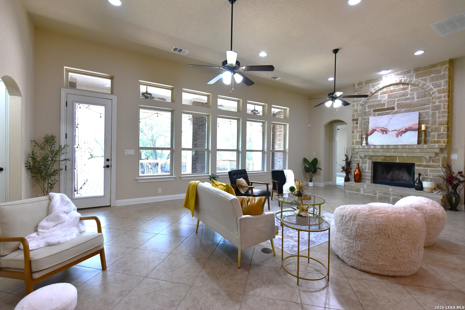 8907 Irving Hill Fair Oaks Ranch, TX 78015 - Photo 10 of 42 a living room with furniture a fireplace and a chandelier