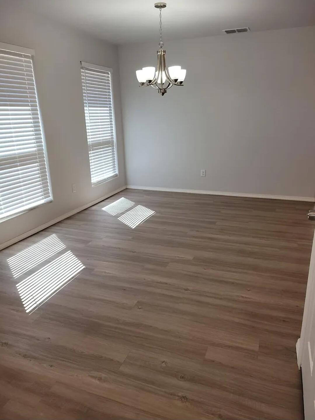 5524 Jarvis Street, Unit B Lubbock, TX 79416 - Photo 2 of 13 wooden floor in an empty room with a window