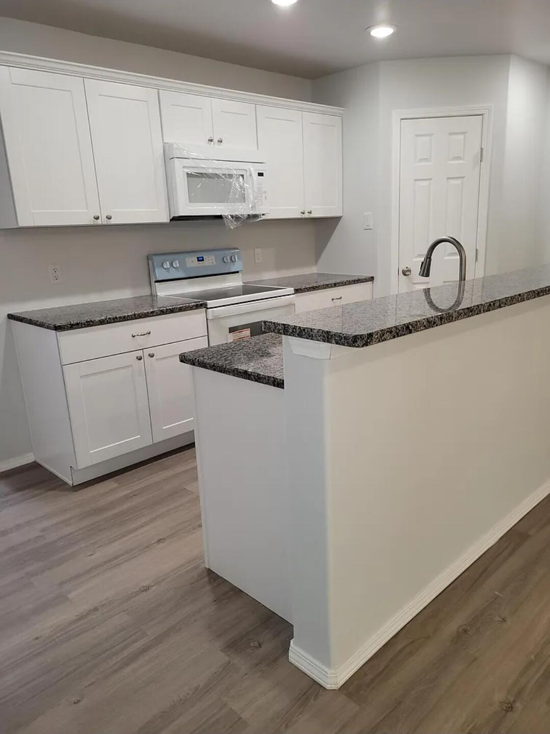 5524 Jarvis Street, Unit B Lubbock, TX 79416 - Photo 4 of 13 a kitchen with wooden cabinets and a sink