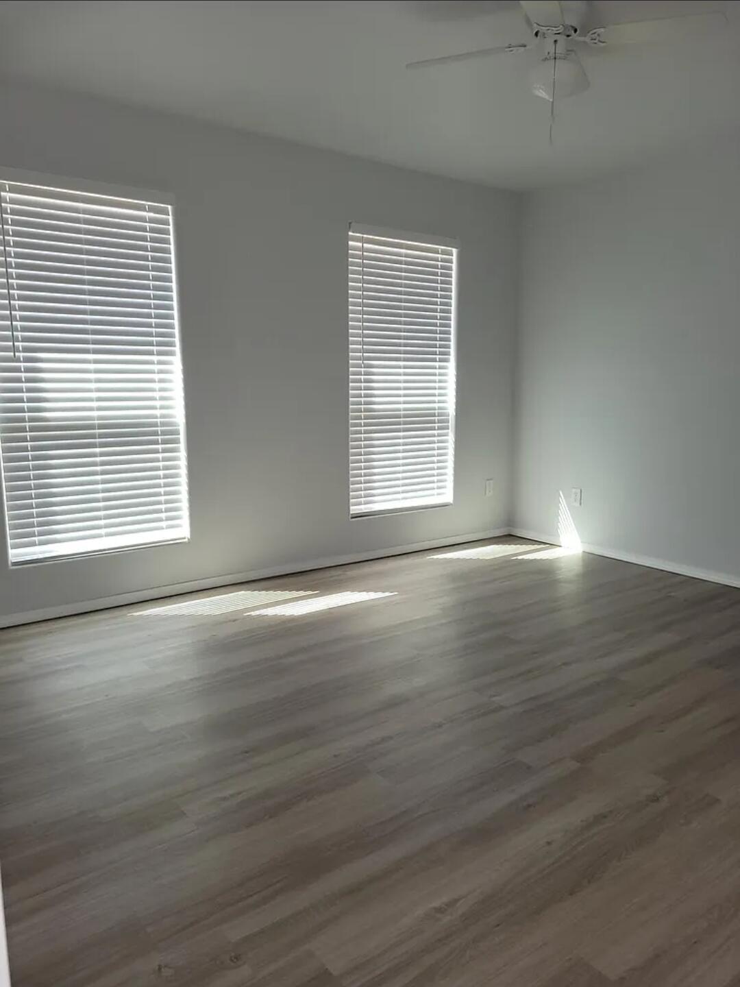 5524 Jarvis Street, Unit B Lubbock, TX 79416 - Photo 10 of 13 an empty room with wooden floor and windows