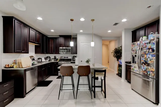 a kitchen with stainless steel appliances kitchen island granite countertop a sink and cabinets