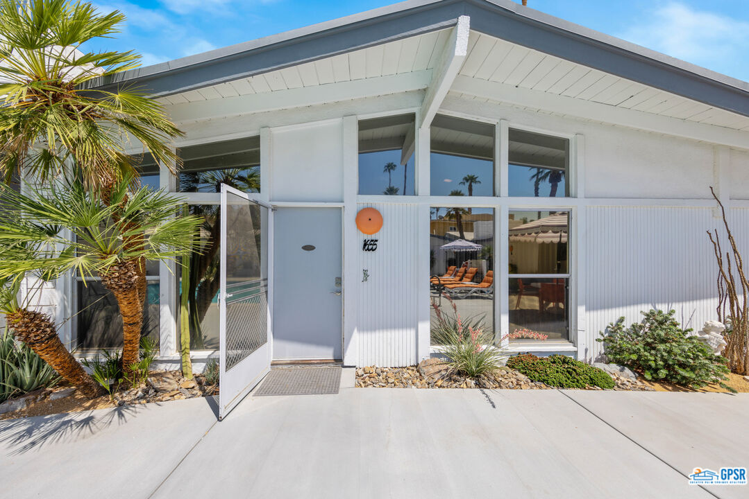 a front view of a house with a tree