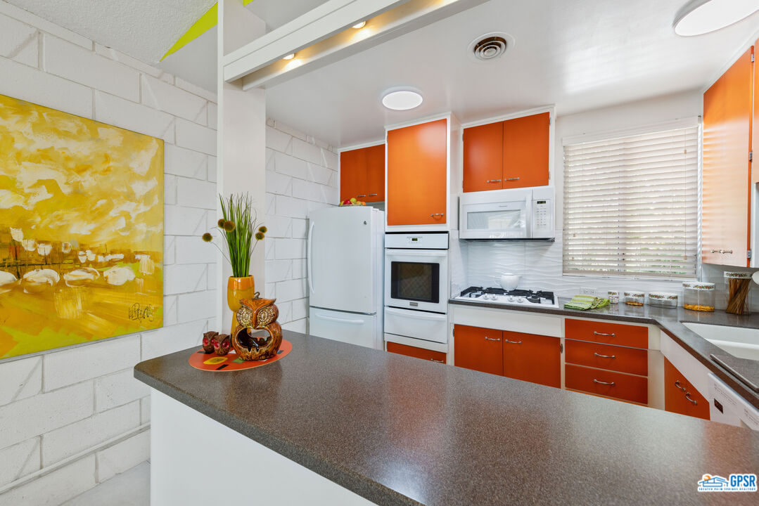 1655 Andee Drive Palm Springs, CA 92264 - Photo 5 of 23 a kitchen with stainless steel appliances granite countertop a sink a stove and a refrigerator