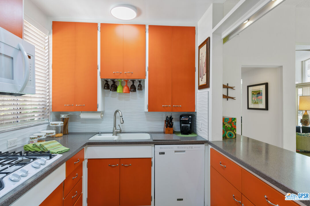 1655 Andee Drive Palm Springs, CA 92264 - Photo 7 of 23 a kitchen with stainless steel appliances wooden cabinets a sink and a large window