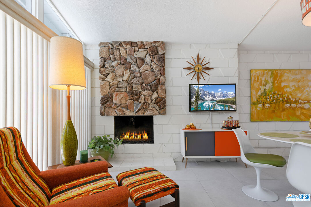 1655 Andee Drive Palm Springs, CA 92264 - Photo 10 of 23 a living room with furniture a fireplace and a flat screen tv