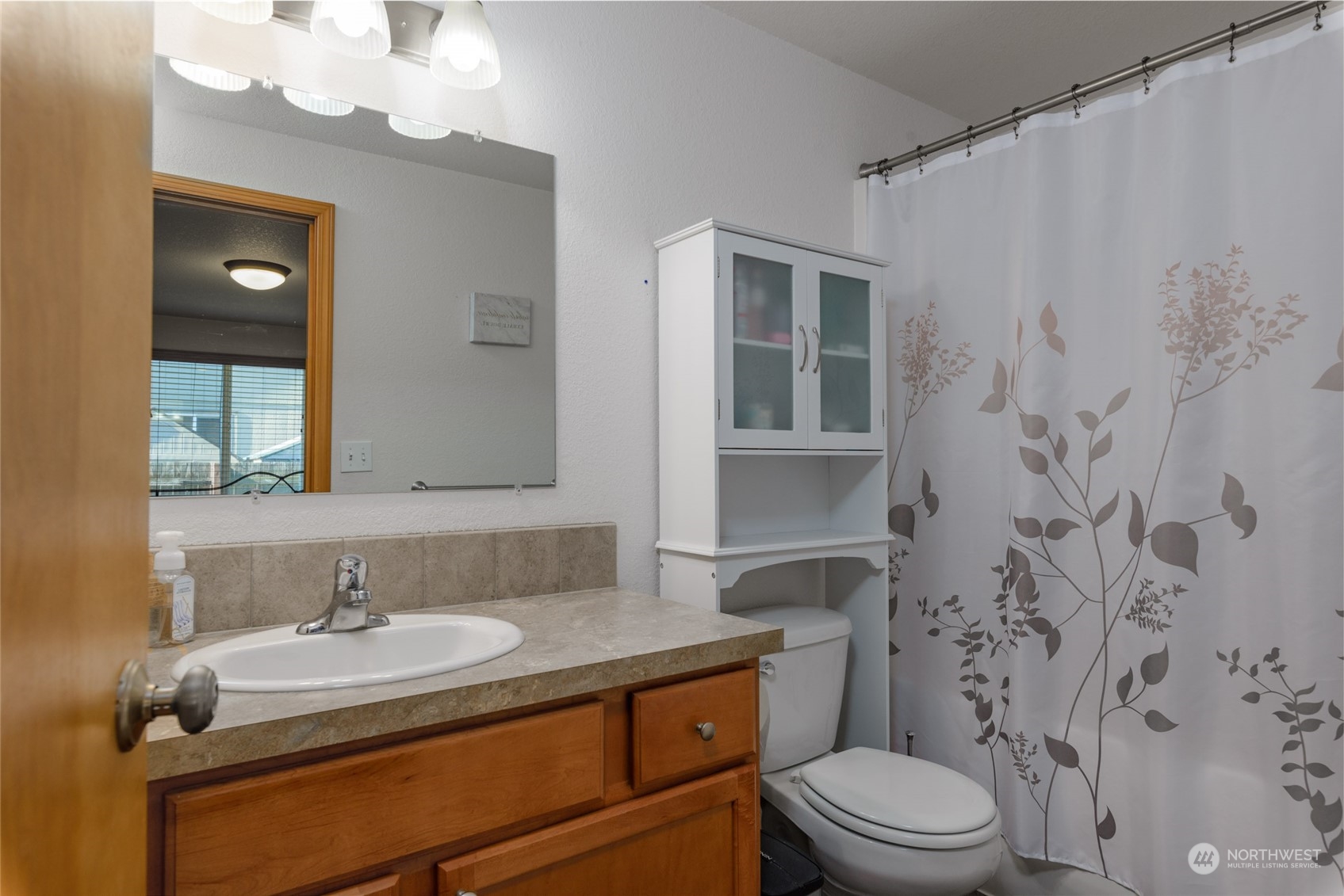 17914 Michelles Lane Southwest Rochester, WA 98579 - Photo 10 of 28 a bathroom with a granite countertop sink toilet a mirror and shower curtain