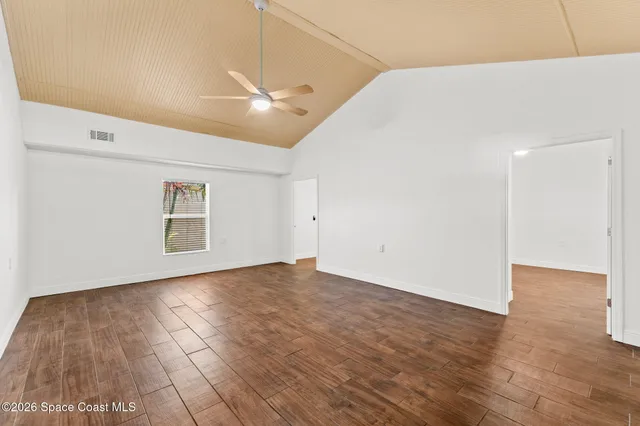 a view of empty room with wooden floor