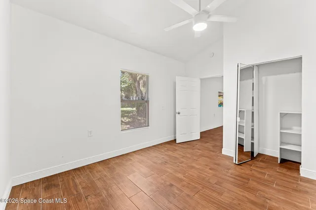 a kitchen with stainless steel appliances granite countertop a stove top oven a refrigerator with white cabinets and wooden floor