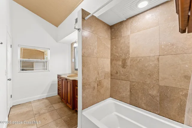 an empty room with wooden floor and a ceiling fan